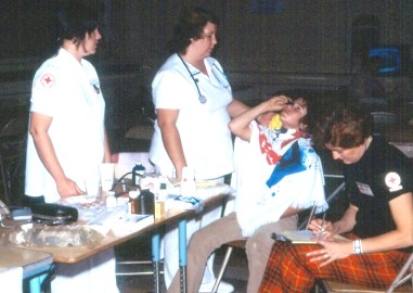 Red Cross nurses in one of the shelters treat a young man whose eyes were affected by smoke and blowing debris.
